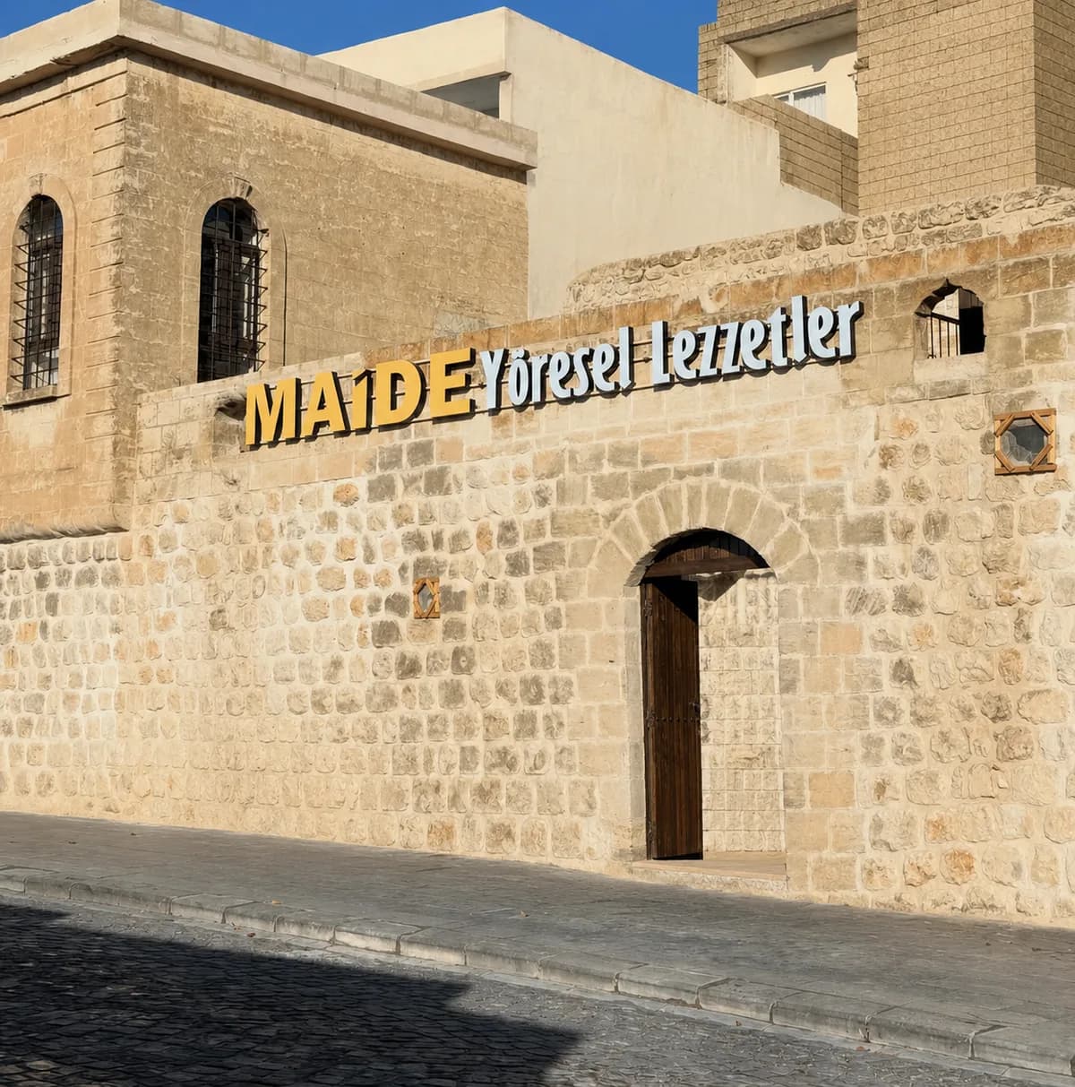 Maide Yöresel Lezzetler — tarihi Mardin taş binası cephesi
