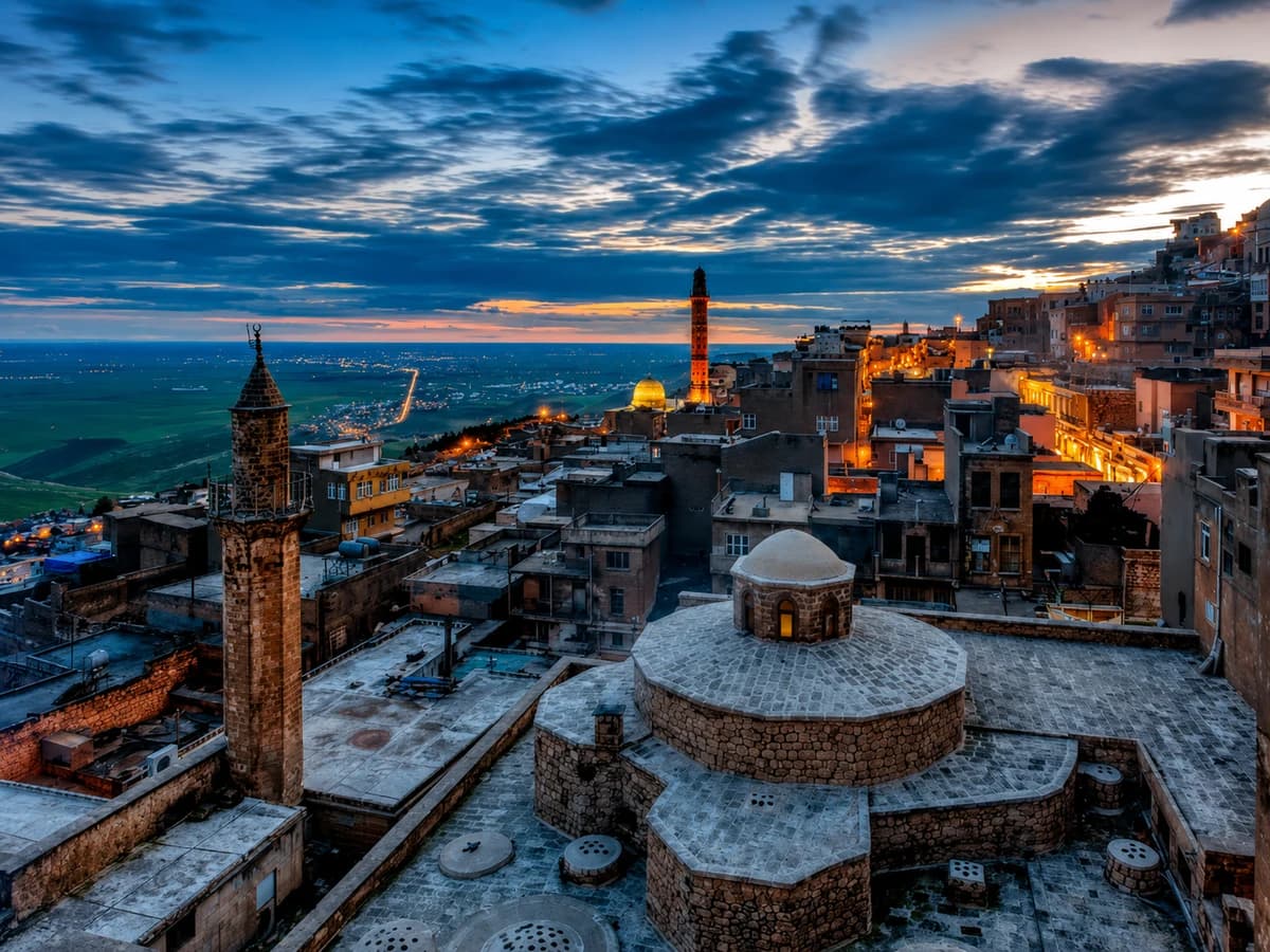 Alacakaranlıkta eski Mardin'in damları ve minareleri