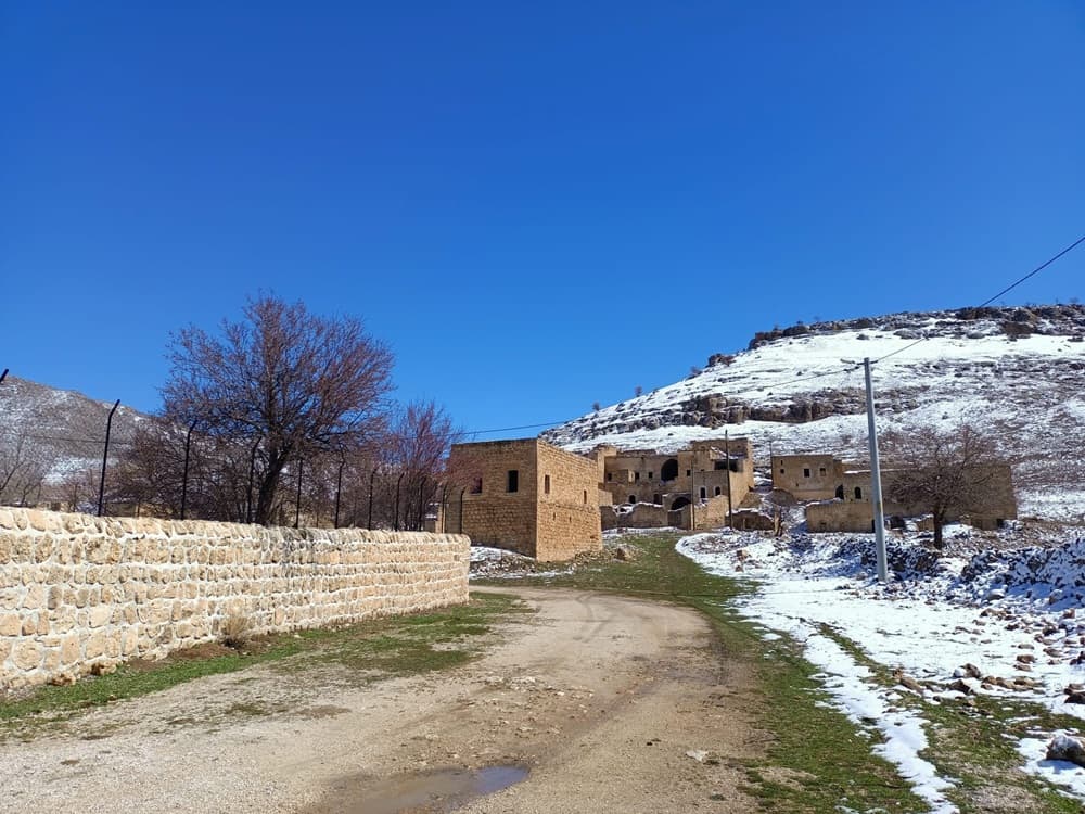 Dereiçi / Killit Köyü'nde taş duvarlar, karlı yamaç ve köye uzanan yol