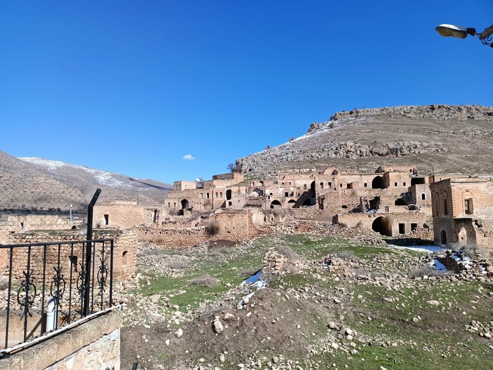Dereiçi / Killit Köyü'nde taş ev kalıntıları, kayalık yamaç ve açık mavi gökyüzü