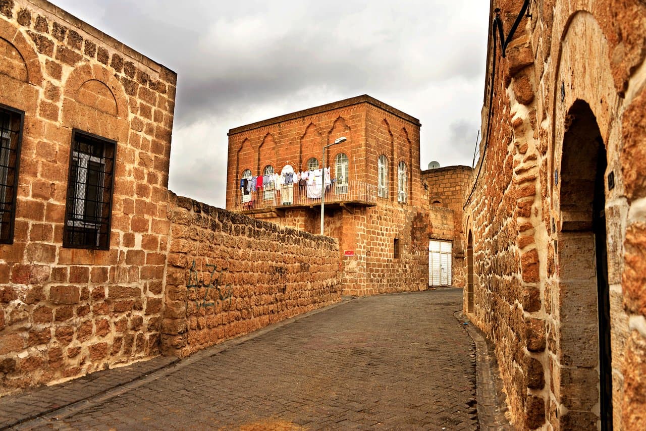 Mardin taş sokaklarında dar geçit ve kemerli yapıların gece görünümü