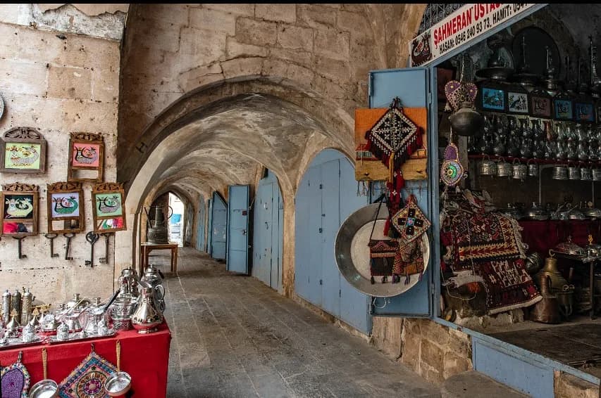 Revaklı Çarşı koridoru, taş kemerler altında sıralanan el sanatları ve gümüş çaydanlıklar